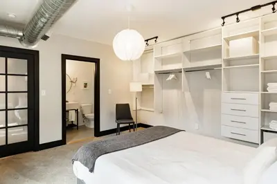 a bedroom with a white bed and a desk at Lux Parkside 1BR - Patio - Sun Deck - Free Parking in Cincinnati