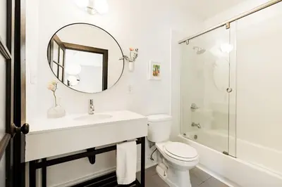 a bathroom with a sink and a toilet and a mirror at Lux Parkside 1BR - Patio - Sun Deck - Free Parking in Cincinnati