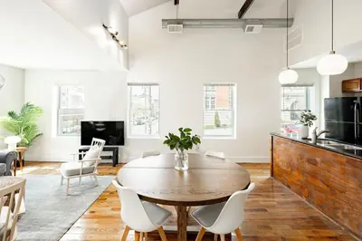 a kitchen and living room with a wooden table and chairs at Soaring 2BR Parkside Loft Walkable to it All in Cincinnati