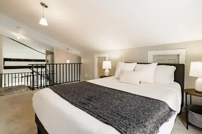 a bedroom with a large white bed with white pillows at Soaring 2BR Parkside Loft Walkable to it All in Cincinnati