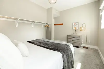 a white bedroom with a bed and a dresser at Explore OTR from a Parkside Condo - Walk to ALL in Cincinnati