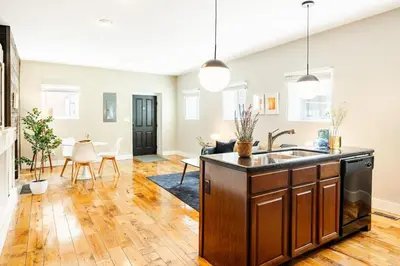 an open kitchen and living room with wooden floors at Explore OTR from a Parkside Condo - Walk to ALL in Cincinnati