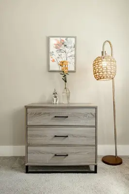 a dresser with a lamp and a vase of flowers on it at Explore OTR from a Parkside Condo - Walk to ALL in Cincinnati