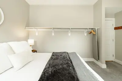 a bedroom with a white bed and a shelf on the wall at Explore OTR from a Parkside Condo - Walk to ALL in Cincinnati