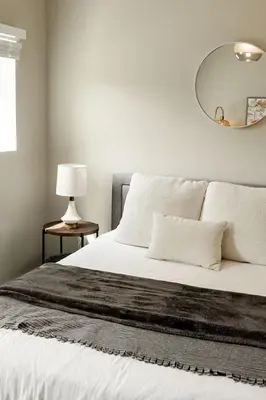 a bedroom with a white bed with a mirror on the wall at Explore OTR from a Parkside Condo - Walk to ALL in Cincinnati