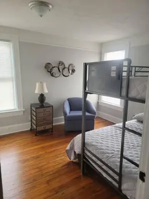 a bedroom with a bunk bed and a chair at 1895 meets 2023 Townhouse. in Hamilton