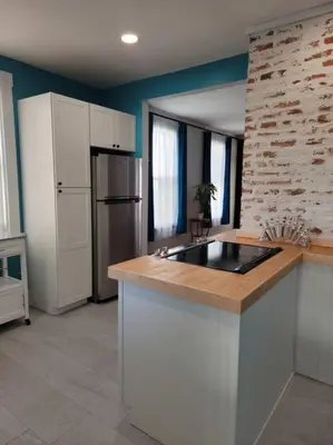 a kitchen with a counter top and a refrigerator at 1895 meets 2023 Townhouse. in Hamilton