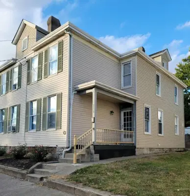 a large house with a porch at 1895 meets 2023 Townhouse. in Hamilton