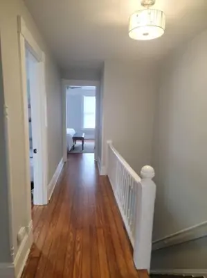 a hallway of a home with a staircase and a room with a hallway at 1895 meets 2023 Townhouse. in Hamilton