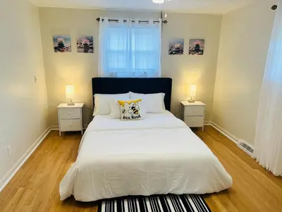 a bedroom with a large white bed with two night stands at Sunshine Palace in West Chester