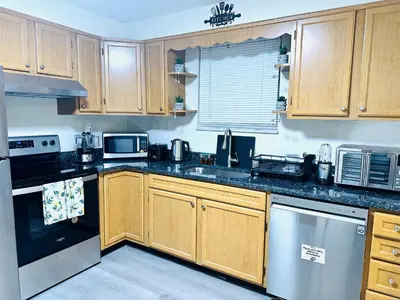 a kitchen with wooden cabinets and stainless steel appliances at Sunshine Palace in West Chester