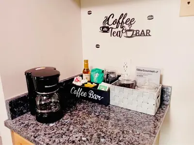 a counter with a coffee maker and a coffee box on it at Sunshine Palace in West Chester