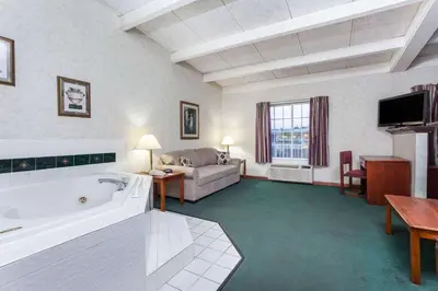 a large living room with a tub and a couch at Days Inn & Suites by Wyndham Lexington in Lexington