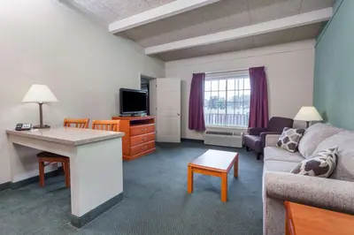 a small living room with a couch and a table at Days Inn & Suites by Wyndham Lexington in Lexington