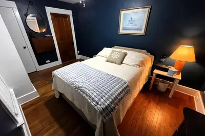 a bedroom with a bed with a blue wall at Fiesinger House - Private 3-bd Unit in Historic Home, Downtown Sandusky in Sandusky