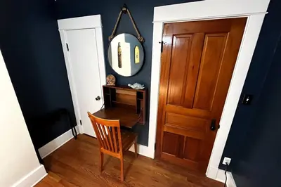 a room with a table and a mirror and a wooden door at Fiesinger House - Private 3-bd Unit in Historic Home, Downtown Sandusky in Sandusky