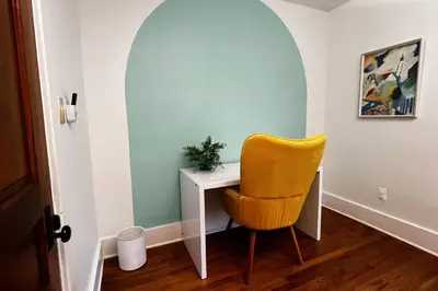 a yellow chair sitting next to a desk in a room at Fiesinger House - Private 3-bd Unit in Historic Home, Downtown Sandusky in Sandusky