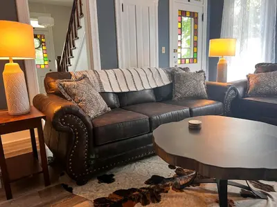 a living room with a leather couch and a table at Guesthouse 214 at Guesthouse Lodging in Millersburg