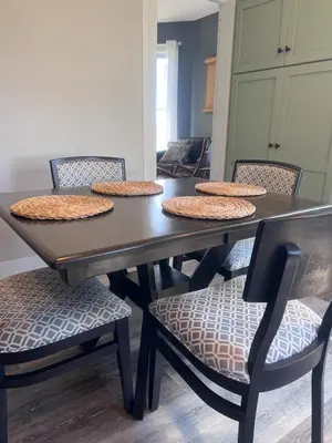 a dining room table and chairs with hats on top at Guesthouse 214 at Guesthouse Lodging in Millersburg