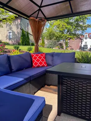 a blue couch and a table under an umbrella at Guesthouse 214 at Guesthouse Lodging in Millersburg