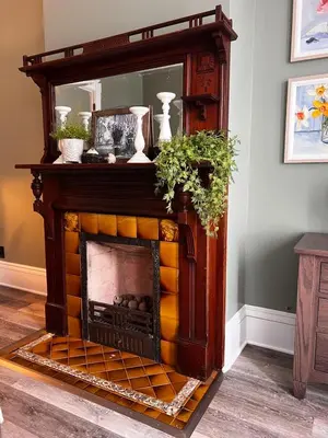a fireplace in a living room with a mirror at Guesthouse 214 at Guesthouse Lodging in Millersburg