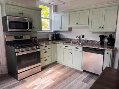 a kitchen with white cabinets and stainless steel appliances at Guesthouse 214 at Guesthouse Lodging in Millersburg