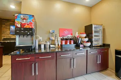 a kitchen with a counter with a refrigerator at Cobblestone Hotel & Suites - Russells Point at Indian Lake in Russells Point