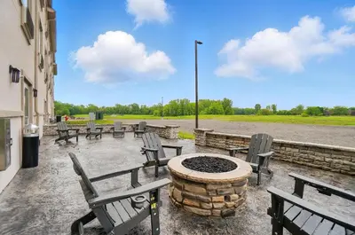 a group of chairs and a fire pit on a patio at Cobblestone Hotel & Suites - Russells Point at Indian Lake in Russells Point
