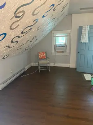 an attic room with a blue door and a chair at Awesome Attic studio3B private room /shared apt in Cincinnati