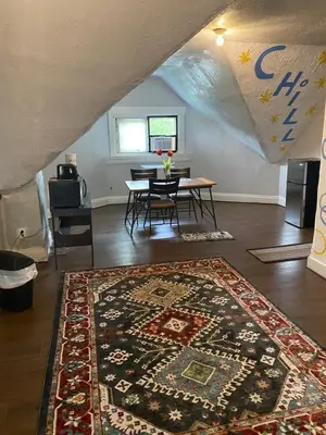 a living room with a table and a rug at Awesome Attic studio3B private room /shared apt in Cincinnati