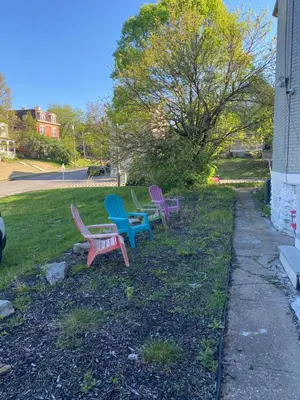 three colorful benches sitting in the grass next to a house at Awesome Attic studio3B private room /shared apt in Cincinnati