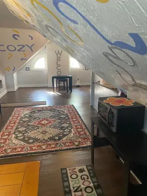 an attic room with a rug on the floor and a staircase at Awesome Attic studio3B private room /shared apt in Cincinnati