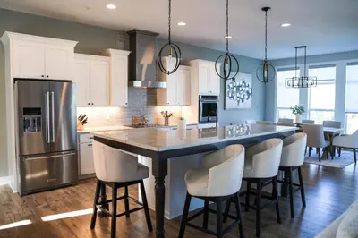 a kitchen with a large island with bar chairs at FeralWoods Private Estate With Hot Tub in Columbia Station