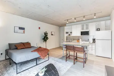 a bedroom with a bed and a kitchen in it at Downtown Chic New Studio Oasis Close to it All in Cleveland