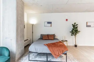 a bedroom with a bed and a blue chair at Downtown Chic New Studio Oasis Close to it All in Cleveland