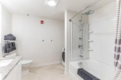 a white bathroom with a shower and a toilet at Downtown Chic New Studio Oasis Close to it All in Cleveland