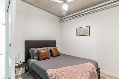 a bedroom with a bed in a white room at DT Delight Downtown Living One-bedroom Endless Access in Cleveland