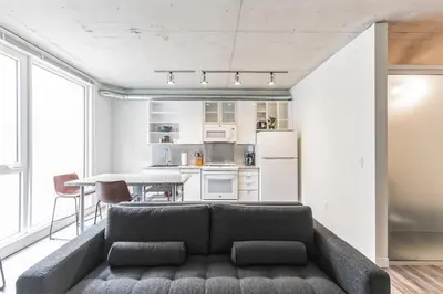 a living room with a couch and a kitchen at DT Delight Downtown Living One-bedroom Endless Access in Cleveland