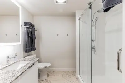 a white bathroom with a shower and a toilet at DT Delight Downtown Living One-bedroom Endless Access in Cleveland