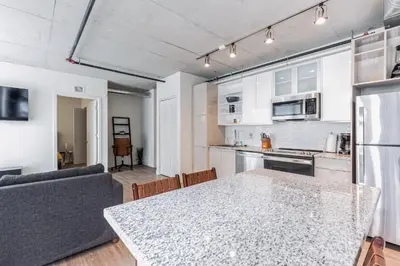 a kitchen and living room with a table and a couch at DT Delight Downtown Living 2bd2ba Endless Access in Cleveland
