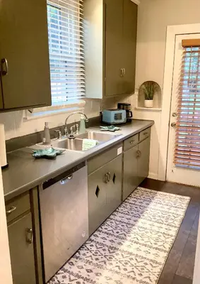 a kitchen with green cabinets and a sink and a rug at Cute 2 Bedroom Home - Huge backyard, near downtown! in Cleveland