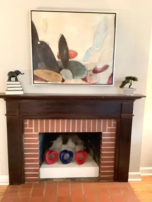 a dog laying in a brick fireplace with two balls at Cute 2 Bedroom Home - Huge backyard, near downtown! in Cleveland