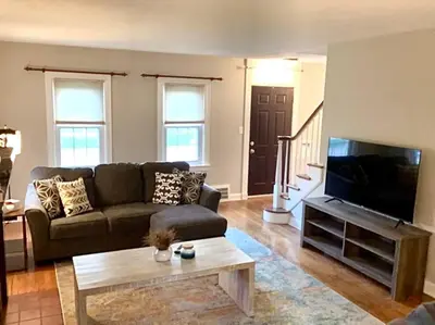 a living room with a couch and a flat screen tv at Cute 2 Bedroom Home - Huge backyard, near downtown! in Cleveland