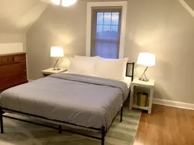 a bedroom with a bed with two lamps and a window at Cute 2 Bedroom Home - Huge backyard, near downtown! in Cleveland