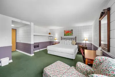 a bedroom with a bed and a table and chairs at The Fountain Inn in Lakeside
