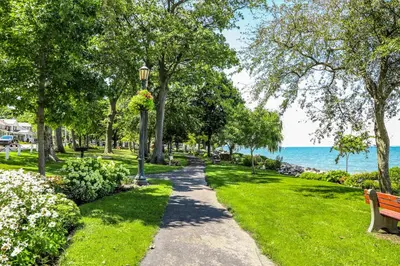 a path through a park with a bench and the ocean at The Fountain Inn in Lakeside