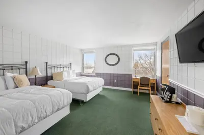 a bedroom with two beds and a flat screen tv at The Fountain Inn in Lakeside