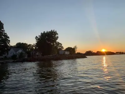 an island in the middle of a river at sunset at Rye Beach Retreat in Huron