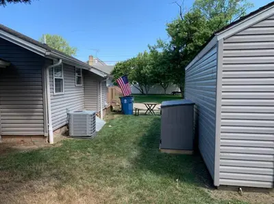 a yard next to a house with an american flag at Rye Beach Retreat in Huron