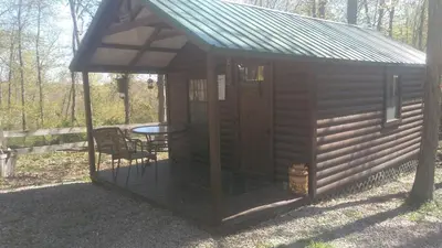 a small cabin with a table and a roof at Two Creeks Camp in Athens